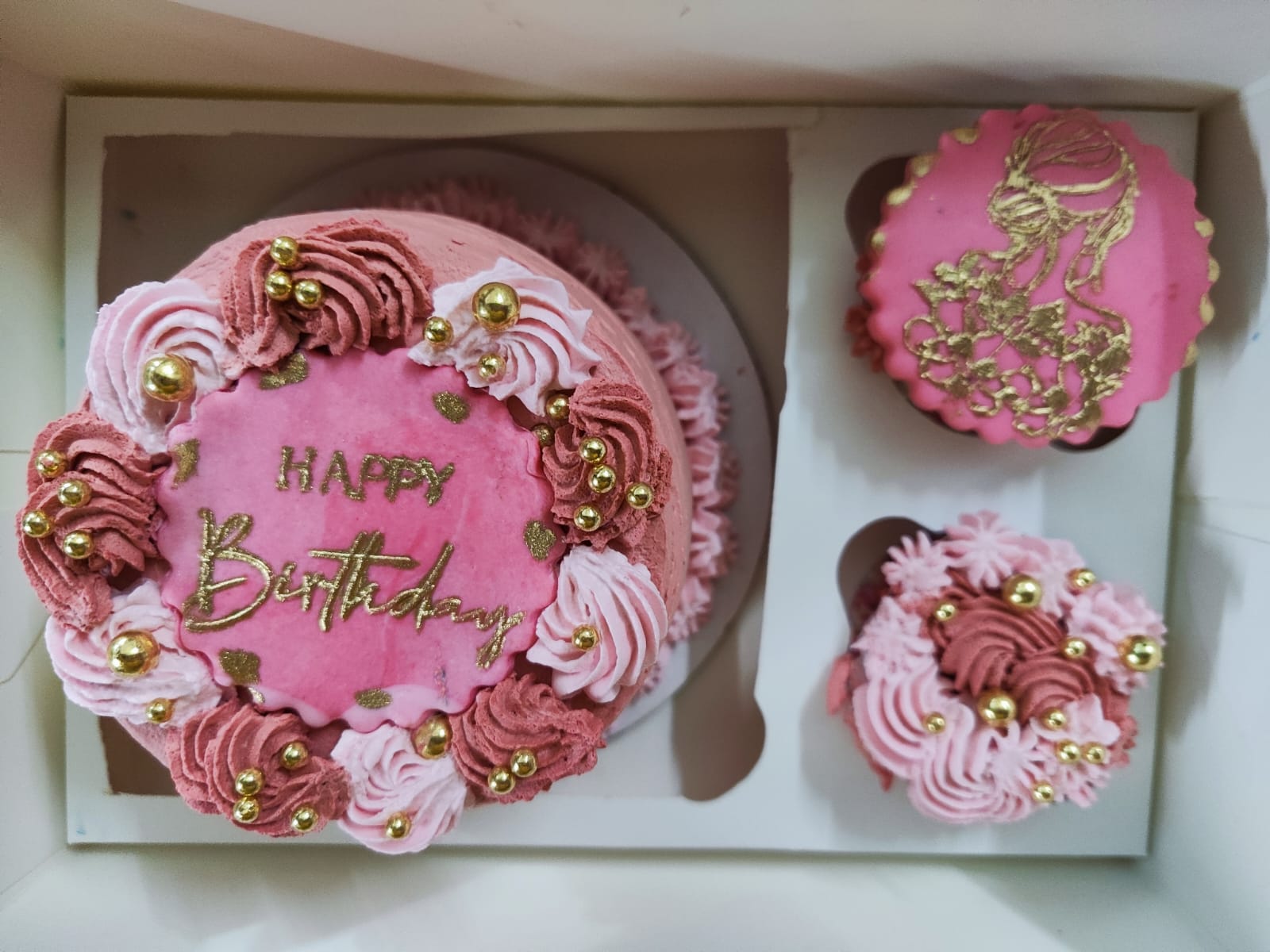 Pink bento birthday cake with matching cupcakes in a gift box